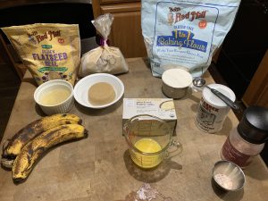 Photo of ingredients for making banana donuts. Ingredients are in bags and bowls pre-measured.