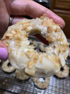 Close-up photo of a gluten free brown sugar glazed donut with coconut flakes.
